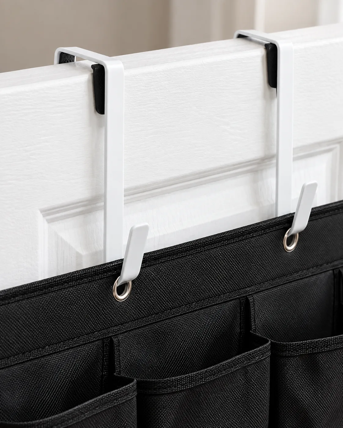 Close-up of white over-door hooks seated over a door edge