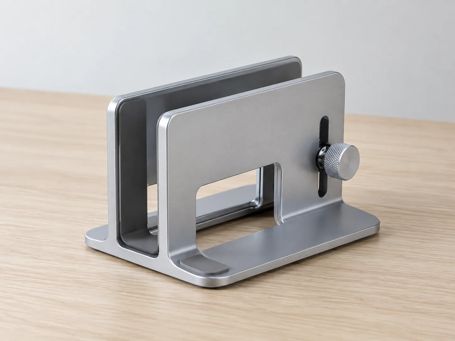 Aluminum vertical laptop stand holding a closed notebook